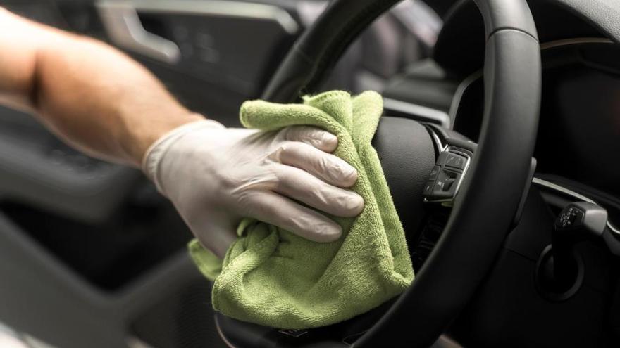 ¿Cómo de sucio está el volante del coche?: Consejos para su limpieza. Imagen que describe a una persona limpiando cuidadosamente el interior de su coche