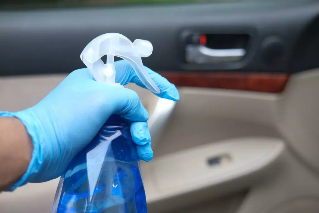 ¿Cómo de sucio está el volante del coche?: Consejos para su limpieza. Imagen que describe a una persona limpiando cuidadosamente el interior de su coche